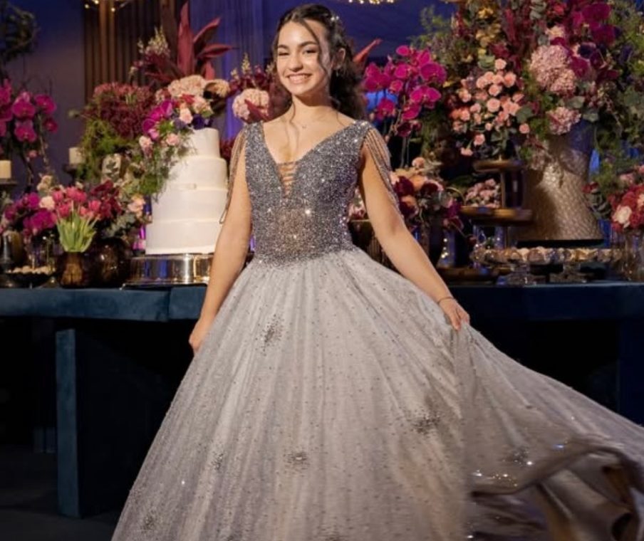 Catarina girando o vestido de cristais em frente à mesa do bolo