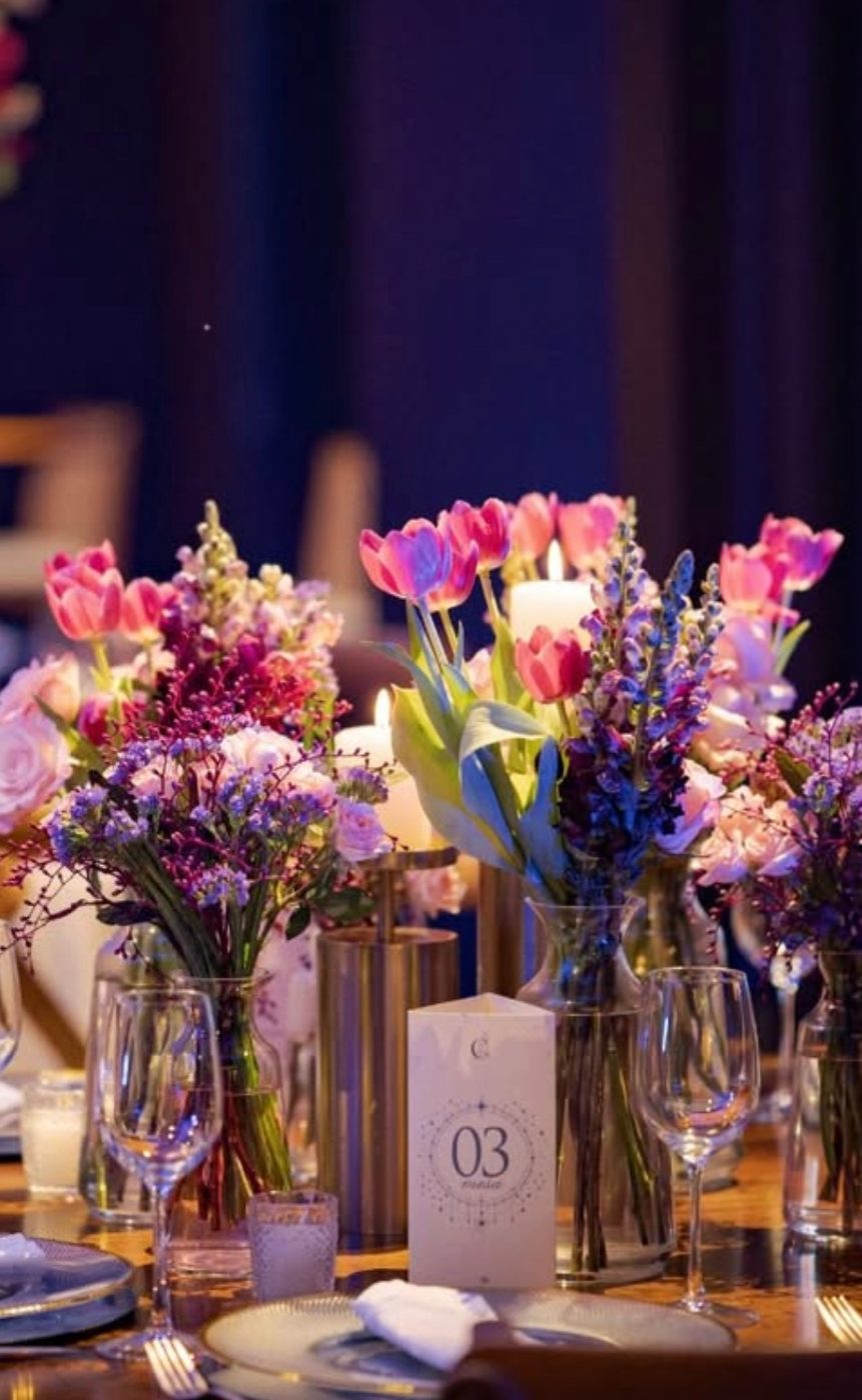 Centro de mesa com tulipas, rosas e velas, e número de mesa
