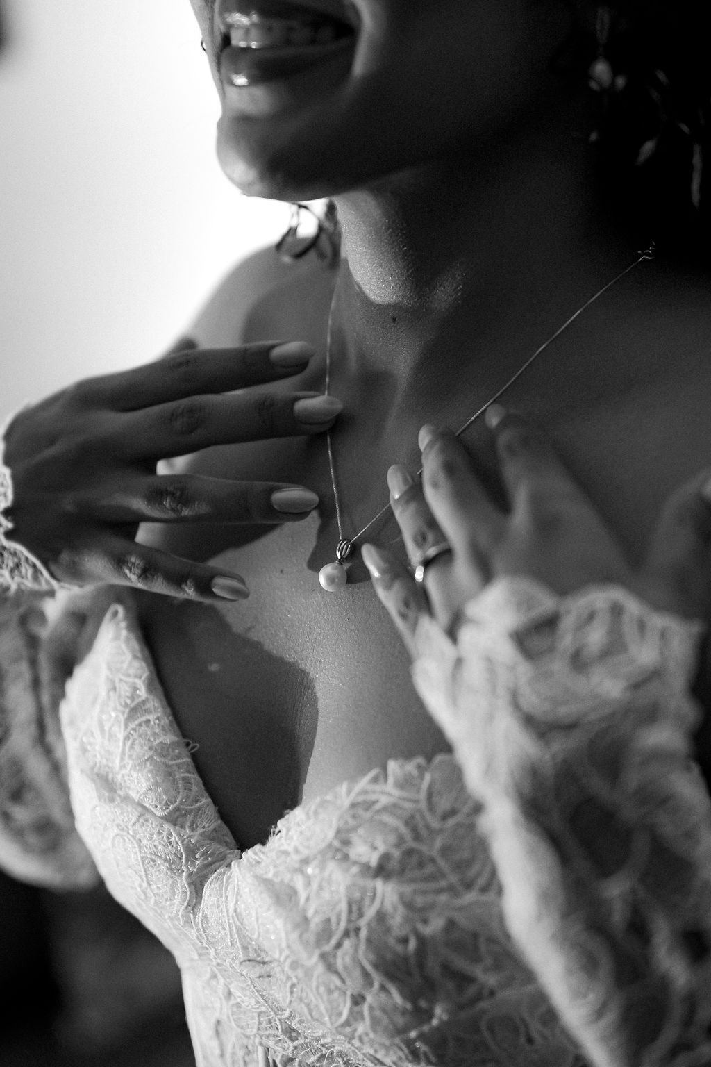 Detalhe em preto e branco do vestido e das mãos da noiva