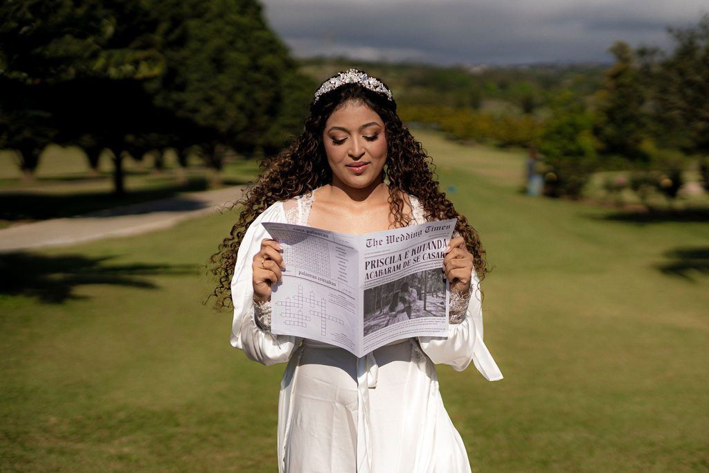 Priscila lendo o jornal personalizado do casamento no gramado