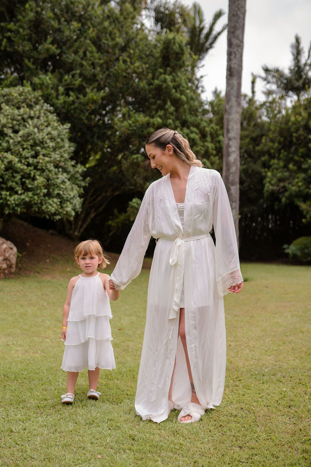 Camila de mãos dadas com a daminha no jardim
