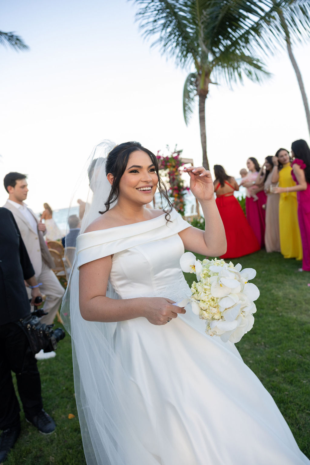 Nathália sorridente com o buquê na saída da cerimônia